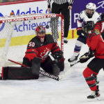 Canada goaltender Kristen Campbell (50) makes a save as United States' Kendall Coyne Schofield (26) and Canada's Jessie Eldridge (9) and Renata Fast (14) look for the puck during the second period of a Rivalry Series hockey game Thursday, Nov. 17, 2022, in Kamloops, British Columbia. (Jesse Johnston/The Canadian Press via AP)