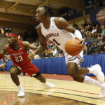 
              Louisville guard Mike James (1) dribbles past Texas Tech guard De'Vion Harmon (23) during the first half of an NCAA college basketball game, Tuesday, Nov. 22, 2022, in Lahaina, Hawaii. (AP Photo/Marco Garcia)
            