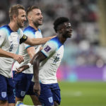 England's Bukayo Saka , right, celebrates with teammates after scoring his side's fourth goal against Iran during the World Cup group B soccer match between England and Iran at the Khalifa International Stadium, in Doha, Qatar, Monday, Nov. 21, 2022. (AP Photo/Martin Meissner)