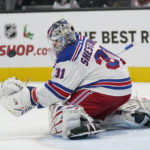 
              New York Rangers goaltender Igor Shesterkin reaches for the puck after defending against a San Jose Sharks shot during the first period of an NHL hockey game in San Jose, Calif., Saturday, Nov. 19, 2022. (AP Photo/Jeff Chiu)
            
