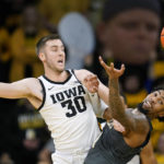 Iowa guard Connor McCaffery (30) fights for a loose ball with Georgia Tech forward Ja'von Franklin during the second half of an NCAA college basketball game, Tuesday, Nov. 29, 2022, in Iowa City, Iowa. (AP Photo/Charlie Neibergall)