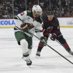 Minnesota Wild defenseman Alex Goligoski (33) handles the puck in front of Carolina Hurricanes center Jack Drury during the first period of an NHL hockey game Saturday, Nov. 19, 2022, in St. Paul, Minn. (AP Photo/Stacy Bengs)