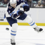 Winnipeg Jets defenseman Dylan DeMelo (2) watches the puck as he passes against the Seattle Kraken during the second period of an NHL hockey game, Sunday, Nov. 13, 2022, in Seattle. (AP Photo/John Froschauer)