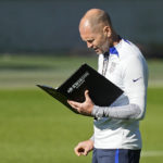 
              FILE - US head coach Gregg Berhalter reads a book during a training session of the US soccer team in Cologne, Germany, prior to a friendly match against Japan, Thursday, Sept. 22, 2022. The World Cup in Qatar will have an unusually truncated build-up to the tournament. World Cups typically take place in June and July at the end of a traditional European soccer season and teams have about three weeks to prepare. (AP Photo/Martin Meissner, File)
            