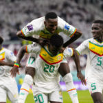 Temmates celebrate with Senegal's Bamba Dieng after he score their third goal against Qatar during a World Cup group A soccer match at the Al Thumama Stadium in Doha, Qatar, Friday, Nov. 25, 2022. (AP Photo/Petr Josek)