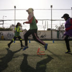 
              Palestinian girls run during a soccer training session at the Beit Hanoun Al-Ahli Youth Club's ground in the northern Gaza strip, Tuesday, Oct. 29, 2022. Women's soccer has been long been neglected in the Middle East, a region that is mad for the men's game and hosts the World Cup for the first time this month in Qatar. (AP Photo/Fatima Shbair)
            