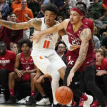 Miami guard Jordan Miller (11) defends Rutgers guard Caleb McConnell (22) during the second half of an NCAA college basketball game, Wednesday, Nov. 30, 2022, in Coral Gables, Fla. (AP Photo/Marta Lavandier)