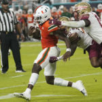 Miami quarterback Jacurri Brown, left is tackled by Florida State defensive back Jammie Robinson, center, and linebacker Tatum Bethune, right, during the first half of an NCAA college football game, Saturday, Nov. 5, 2022, in Miami Gardens, Fla.(AP Photo/Lynne Sladky)
