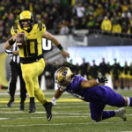 Oregon quarterback Bo Nix (10) eludes a tackle by Washington defensive lineman Voi Tunuufi (90) during the first half of an NCAA college football game Saturday, Nov. 12, 2022, in Eugene, Ore. (AP Photo/Andy Nelson)