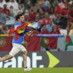 
              A pitch invader runs onto the pitch with a rainbow flag during the World Cup group H soccer match between Portugal and Uruguay, at the Lusail Stadium in Lusail, Qatar, Monday, Nov. 28, 2022. (AP Photo/Themba Hadebe)
            