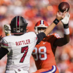 South Carolina quarterback Spencer Rattler (7) tries to pass the ball over Clemson defensive end Myles Murphy (98) in the first half of an NCAA college football game on Saturday, Nov. 26, 2022, in Clemson, S.C. (AP Photo/Jacob Kupferman)