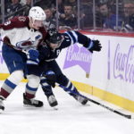 Colorado Avalanche's Cale Makar (8) checks Winnipeg Jets' Adam Lowry during the second period of an NHL hockey game in Winnipeg, Manitoba, on Tuesday, Nov. 29, 2022. (Greenslade/The Canadian Press via AP)