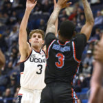 Connecticut guard Joey Calcaterra (3) shoots over Delaware State guard Martaz Robinson (3) during the first half of an NCAA college basketball game, Sunday, Nov. 20, 2022, in Hartford, Conn. (AP Photo/Jessica Hill)