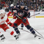 Columbus Blue Jackets' Boone Jenner, right, tries to carry the puck past Detroit Red Wings' Filip Hronek during the second period of an NHL hockey game, Saturday, Nov. 19, 2022, in Columbus, Ohio. (AP Photo/Jay LaPrete)