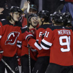 New Jersey Devils center Jack Hughes, second from left, celebrates with teammates after scoring his second goal of the period against the Washington Capitals during the second period of an NHL hockey game, Saturday, Nov. 26, 2022, in Newark, N.J. (AP Photo/Adam Hunger)