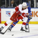 Detroit Red Wings center Michael Rasmussen (27) shields the puck from New York Rangers left wing Jimmy Vesey during the first period of an NHL hockey game Sunday, Nov. 6, 2022, in New York. (AP Photo/John Munson)