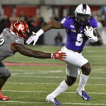 James Madison running back Latrele Palmer (5) runs from the tackle attempt by Louisville linebacker Yasir Abdullah (22) during the first half of an NCAA college football game in Louisville, Ky., Saturday, Nov. 5, 2022. (AP Photo/Timothy D. Easley)