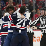 Tampa Bay Lightning left wing Pat Maroon, left, fights with Washington Capitals right wing Garnet Hathaway as linesman Michel Cormier, right, tries to separate them in the second period of an NHL hockey game, Friday, Nov. 11, 2022, in Washington. (AP Photo/Patrick Semansky)