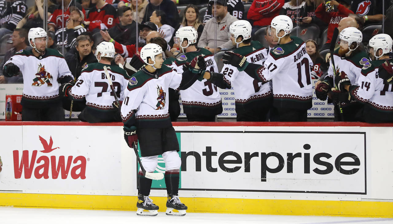 Arizona Coyotes right wing Dylan Guenther celebrates with teammates after scoring a goal against th...