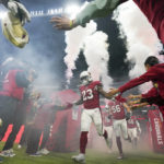 Players for the Arizona Cardinals run onto the field before an NFL football game against the San Francisco 49ers, Monday, Nov. 21, 2022, in Mexico City. (AP Photo/Fernando Llano)