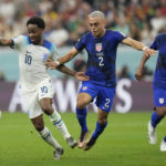 Sergino Dest of the United States, centre, challenges for the ball with England's Raheem Sterling during the World Cup group B soccer match between England and The United States, at the Al Bayt Stadium in Al Khor, Qatar, Friday, Nov. 25, 2022. (AP Photo/Andre Penner)
