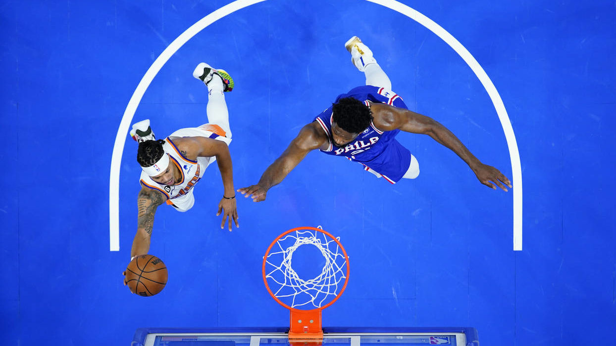 Phoenix Suns' Damion Lee, left, goes up for a shot against Philadelphia 76ers' Joel Embiid during t...