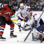 New Jersey Devils left wing Erik Haula (56) attempts to knock the puck out of the glove of Washington Capitals goaltender Charlie Lindgren during the second period of an NHL hockey game Saturday, Nov. 26, 2022, in Newark, N.J. (AP Photo/Adam Hunger)