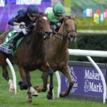 
              Ryan Moore rides Tuesday to victory past Joel Rosario on In Italian in the Breeders' Cup Filly & Mare Turf race at the Keenelend Race Course, Saturday, Nov. 5, 2022, in Lexington, Ky. (AP Photo/Darron Cummings)
            