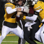 New Mexico State quarterback Gavin Frakes, center, fights his way to the end zone between Missouri's Jalani Williams, right, and Tyler Jones, left, during the fourth quarter of an NCAA college football game Saturday, Nov. 19, 2022, in Columbia, Mo. Missouri won 45-14. (AP Photo/L.G. Patterson)