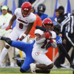 
              Kentucky defensive back Jordan Lovett (25) tackles Louisville running back Maurice Turner (20) during the first half of an NCAA college football game in Lexington, Ky., Saturday, Nov. 26, 2022. (AP Photo/Michael Clubb)
            