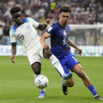 Antonee Robinson of the United States vies for the ball with England's Bukayo Saka, left, during the World Cup group B soccer match between England and The United States, at the Al Bayt Stadium in Al Khor , Qatar, Friday, Nov. 25, 2022. (AP Photo/Luca Bruno)