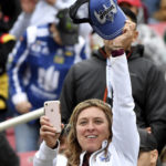 
              FILE - A Jimmie Johnson fan waves her cap during introductions prior to a NASCAR Cup Series auto race Sunday, March 1, 2020, in Fontana, Calif. Seven-time NASCAR champion Jimmie Johnson is returning to NASCAR two years after his retirement from the stock car series.  (AP Photo/Will Lester)
            
