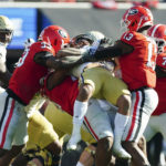 
              Georgia Tech running back Dontae Smith (4) is stopped by Georgia defenders Robert Beal Jr. (33) and Mykel Williams (13) during the first half of an NCAA college football game Saturday, Nov. 26, 2022 in Athens, Ga. (AP Photo/John Bazemore)
            