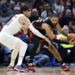 
              Miami Heat forward Caleb Martin, right, plays against Cleveland Cavaliers forward Cedi Osman, left, during the first half of an NBA basketball game, Sunday, Nov. 20, 2022, in Cleveland. (AP Photo/Ron Schwane)
            