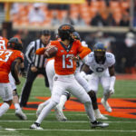 Oklahoma State quarterback Garret Rangel passes the ball during the first quarter the NCAA college football game against West Virginia in Stillwater, Okla., Saturday Nov. 26, 2022. (AP Photo/Mitch Alcala)