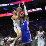 
              Phoenix Suns' Devin Booker, left, goes up for a shot against Philadelphia 76ers' Paul Reed during the second half of an NBA basketball game, Monday, Nov. 7, 2022, in Philadelphia. (AP Photo/Matt Slocum)
            