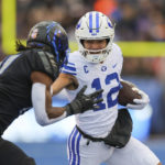 BYU wide receiver Puka Nacua (12) stiff-arms Boise State cornerback Tyreque Jones, left, after a catch in the first half of an NCAA college football game, Saturday, Nov. 5, 2022, in Boise, Idaho. (AP Photo/Steve Conner)