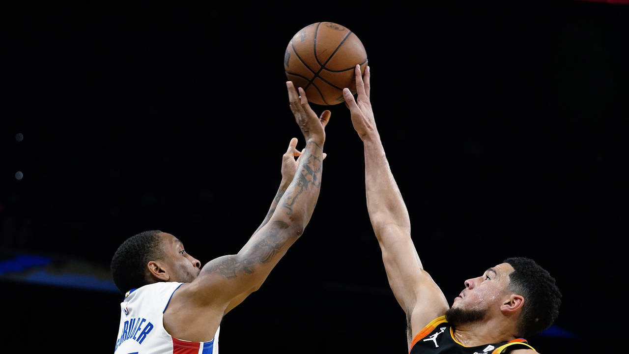 Phoenix Suns' Devin Booker (1) blocks a shot from Detroit Pistons' Rodney McGruder (17) during the ...