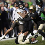 
              Oregon wide receiver Kris Hutson, back left, is stopped after catching a pass by Colorado safety Tyrin Taylor, front, and cornerback Kaylin Moore, back, right, in the first half of an NCAA college football game, Saturday, Nov. 5, 2022, in Boulder, Colo. (AP Photo/David Zalubowski)
            