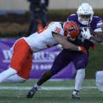 
              Northwestern running back Cam Porter is tackled by Illinois linebacker Isaac Darkangelo (38) during the first half of an NCAA college football game in Evanston, Ill., Saturday, Nov. 26, 2022. (AP Photo/Nam Y. Huh)
            