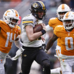 
              Missouri quarterback Brady Cook (12) runs for yardage as he is chased by Tennessee defensive back Doneiko Slaughter (0), and defensive back Christian Charles (14) during the first half of an NCAA college football game Saturday, Nov. 12, 2022, in Knoxville, Tenn. (AP Photo/Wade Payne)
            