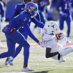 Texas wide receiver Xavier Worthy, right, is stopped by Kansas cornerback Ra'Mello Dotson (3) during the first quarter of an NCAA college football game on Saturday, Nov. 19, 2022, in Lawrence, Kan. (AP Photo/Colin E. Braley)