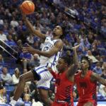 Kentucky's Antonio Reeves (12) shoots near Duquesne's Tevin Brewer (0) and Jimmy "Tre" Clark III (1) during the second half of an NCAA college basketball game in Lexington, Ky., Friday, Nov. 11, 2022. (AP Photo/James Crisp)