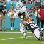 Miami Dolphins wide receiver Tyreek Hill (10) grabs a pass in the endzone for a touchdown as Cleveland Browns cornerback Greg Newsome II (20) attempts to tackle during the second half of an NFL football game, Sunday, Nov. 13, 2022, in Miami Gardens, Fla. (AP Photo/Lynne Sladky)