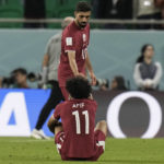 
              Qatar's Hassan Al-Haydos helps Akram Afif stand up after the World Cup group A soccer match between Qatar and Senegal, at the Al Thumama Stadium in Doha, Qatar, Friday, Nov. 25, 2022. Senegal won 3-1. (AP Photo/Hassan Ammar)
            