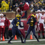 
              Nebraska wide receiver Alante Brown (4) is upended by Michigan defensive back Mike Sainristil (0) as DJ Turner (5) looks on in the first half of an NCAA college football game in Ann Arbor, Mich., Saturday, Nov. 12, 2022. (AP Photo/Paul Sancya)
            
