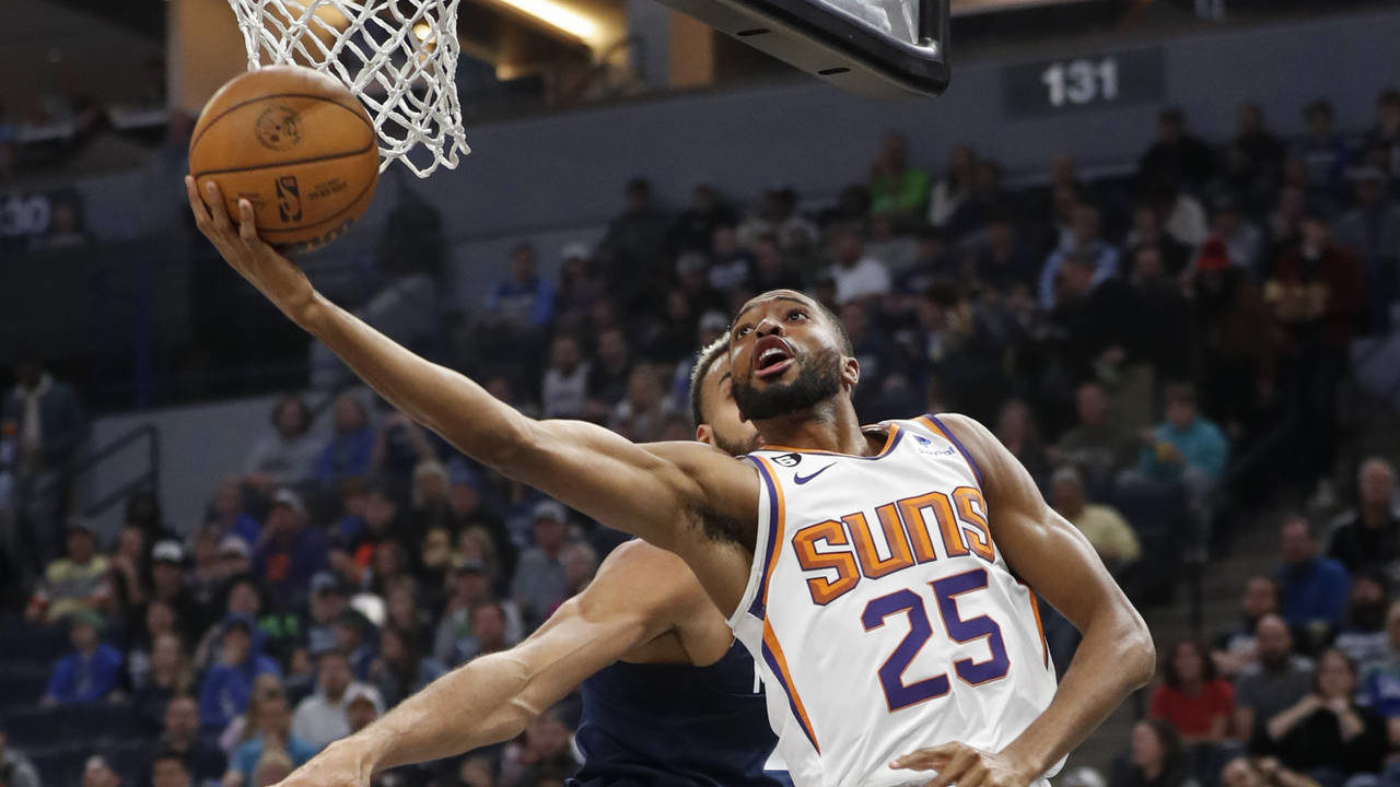 Phoenix Suns forward Mikal Bridges (25) moves past Minnesota Timberwolves center Rudy Gobert to sco...