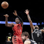 
              Portland Trail Blazers forward Jerami Grant (9) passes the ball away frolm Brooklyn Nets guard Kyrie Irving (11) during the first half of an NBA basketball game Sunday, Nov. 27, 2022, in New York. (AP Photo/Jessie Alcheh)
            