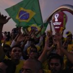 
              Fans cheer and wave Brazilian flags in front of the World Cup countdown clock in Doha, Qatar, Friday, Nov. 18, 2022. Fans poured into Qatar on Friday ahead of the Middle East's first World Cup as Doha ordered beers not to be poured out at stadiums during the tournament — a last-minute surprise largely welcomed by the country's conservative Muslims and shrugged off by giddy fans. (AP Photo/Jon Gambrell)
            