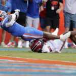Florida running back Trevor Etienne (7) scores an 85-yard touchdown past South Carolina defensive back Cam Smith (9) in the first half of an NCAA college football game, Saturday, Nov. 12, 2022, in Gainesville, Fla. (AP Photo/Matt Stamey)